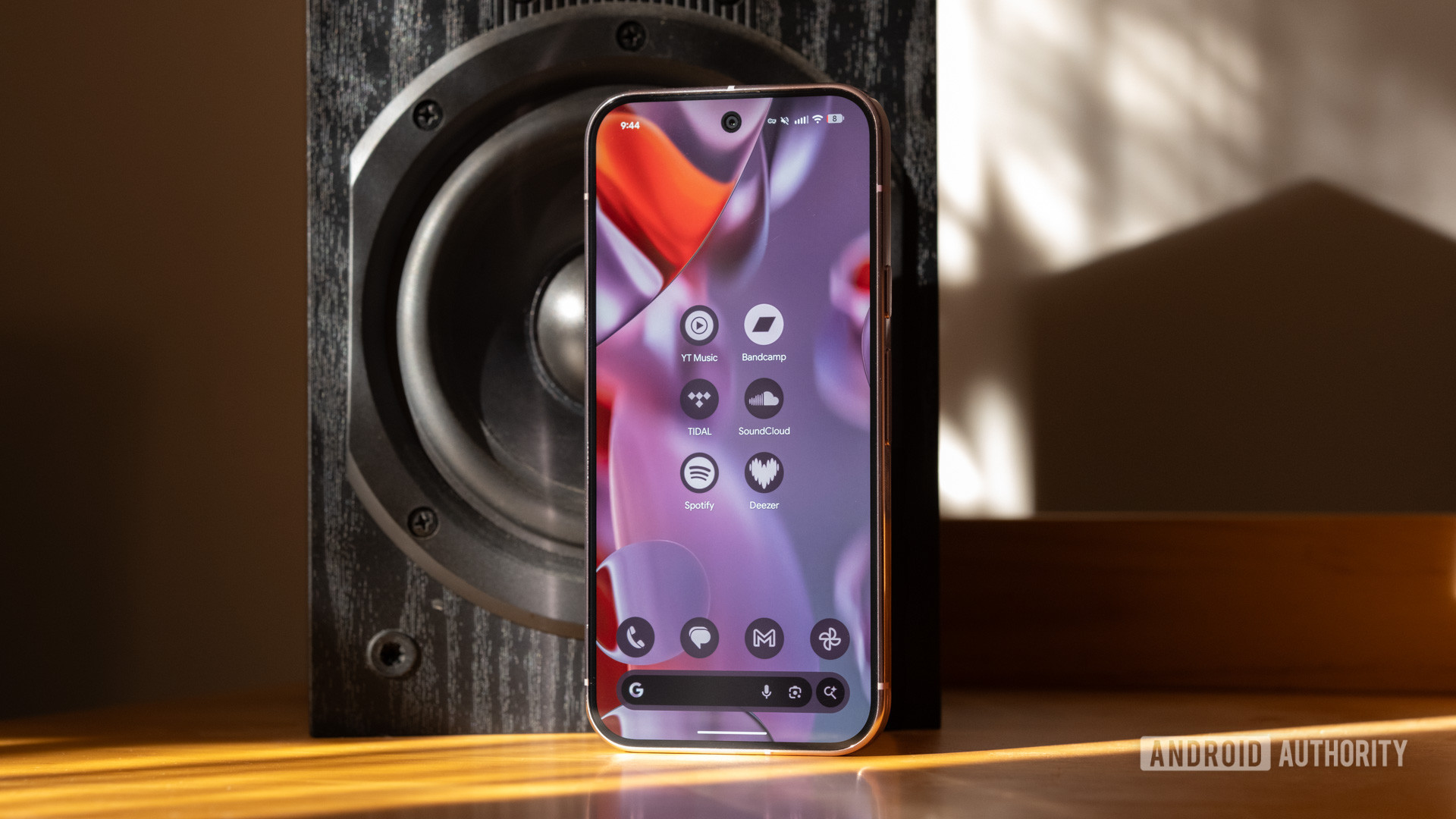 A Pixel 9 Pro next to a speaker, displaying several music streaming app icons.