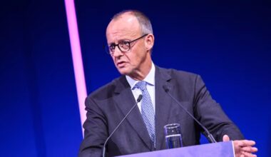 Friedrich Merz speaks at a podium with microphones during the Hightech Agenda event.