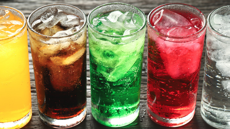 Assorted soft drinks in glasses with ice