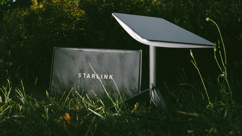 Starlink dish and cardboard packaging on grassy background