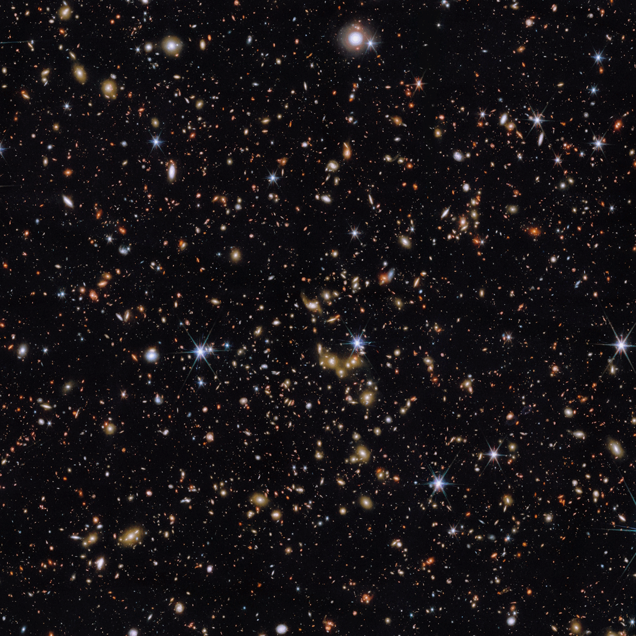 A dense field of distant galaxies and stars scattered across the dark expanse of space.