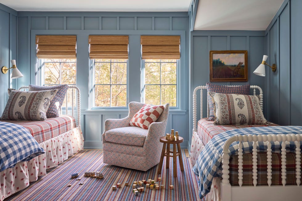 bunk room with blue walls and two white spindle twin beds