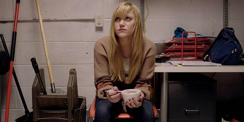 Jay sits in a janitor's closet while eating in It Follows