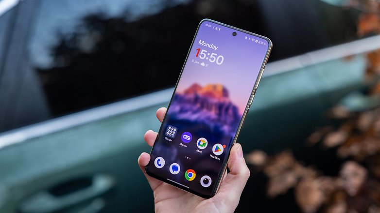 A person holding a OnePlus 13 smartphone with a colorful home screen showing the time 15:50. A person holding a OnePlus 13 smartphone with a colorful home screen showing the time 15:50.