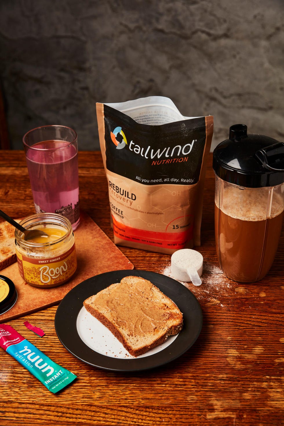 a nutritious meal setup including a protein powder a drink a slice of bread with spread and hydration supplements a nutritious meal setup including a protein powder a drink a slice of bread with spread and hydration supplements