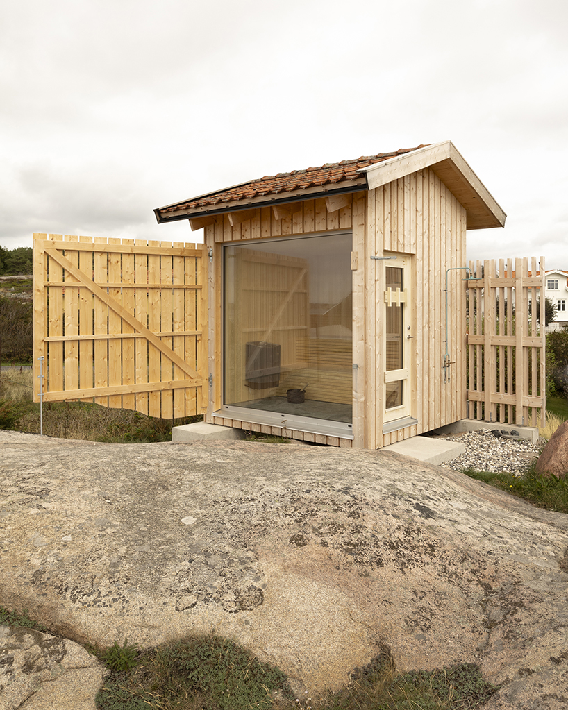 untreated wooden cladding wraps vernacular sauna sövall on sweden's rocky shoreline