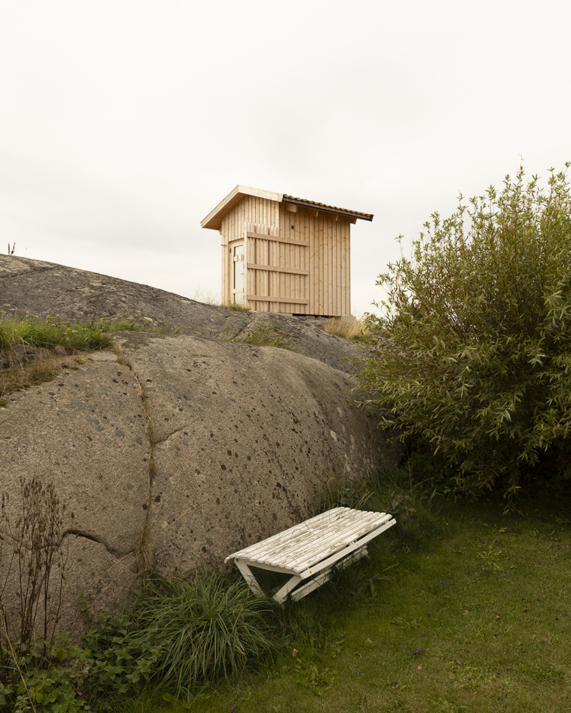 untreated wooden cladding wraps vernacular sauna sövall on sweden's rocky shoreline