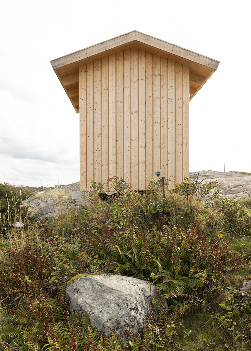 untreated wooden cladding wraps vernacular sauna sövall on sweden's rocky shoreline