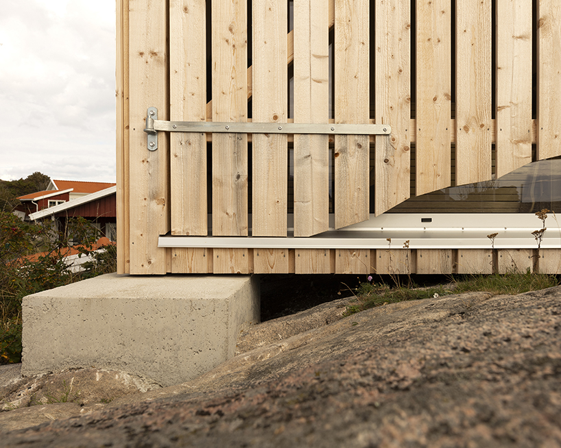 untreated wooden cladding wraps vernacular sauna sövall on sweden's rocky shoreline