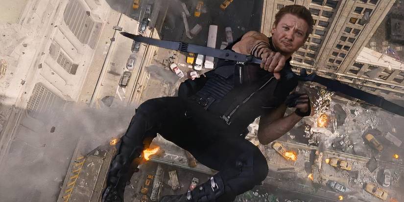 Hawkeye dives off the side of a building while shooting his arrow 