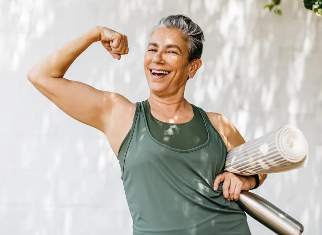 Senior woman flaunting her strong bicep, celebrating her fitness achievement after a workout session. Happy elderly woman taking pride in her fitness journey and the physical strength she has achieved