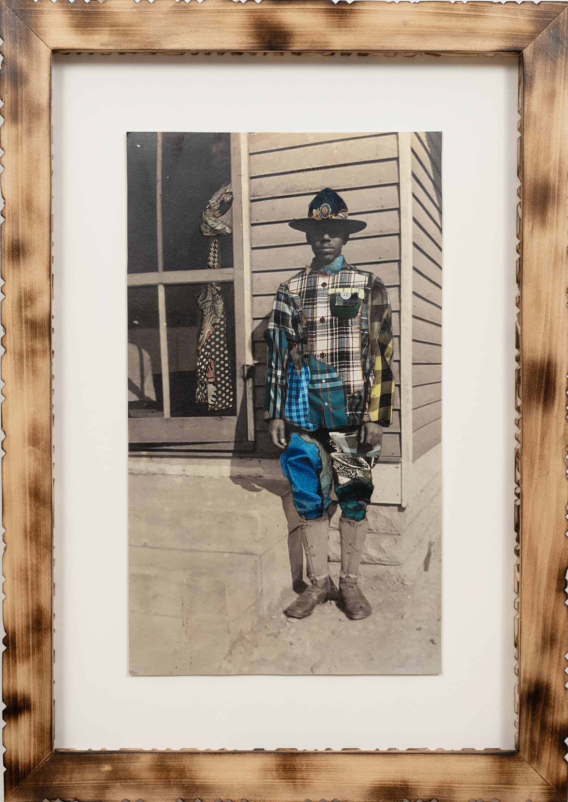 a framed portrait by Stan Squirewell, from an old photograph, of a Black man wearing a hat, with colorful, patterned fabrics collaged onto the image
