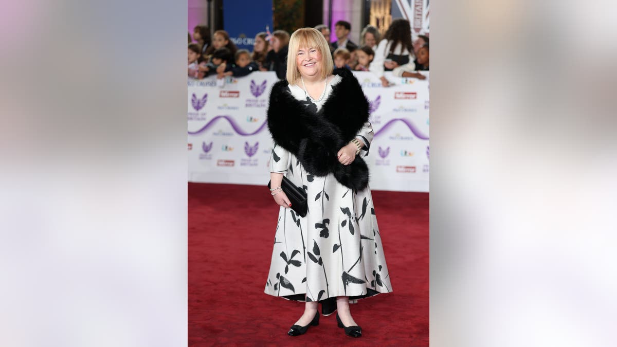 Susan Boyle in a black and white floral dress on the red carpet