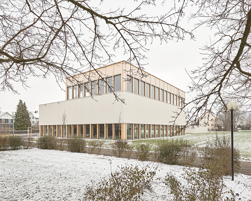 vertical timber construction shapes twin stacked sports halls in switzerland by kit