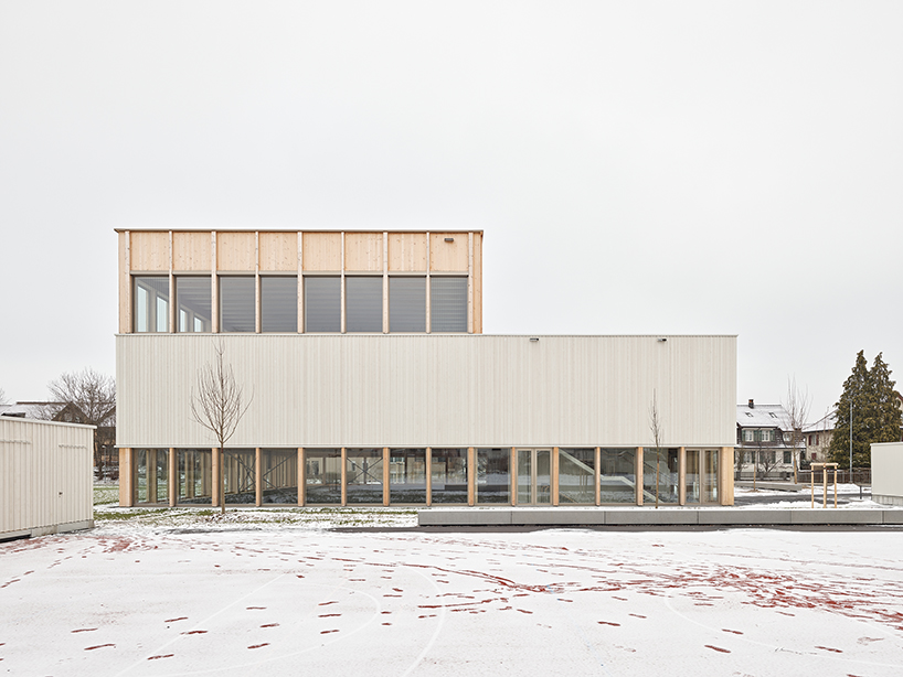 vertical timber construction shapes twin stacked sports halls in switzerland by kit