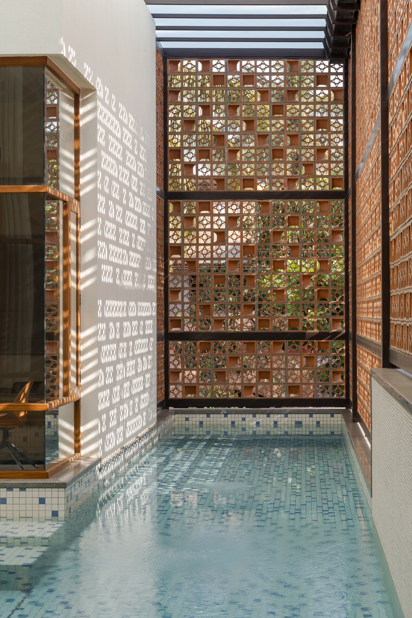 perforated terracotta screens enclose pool pavilion within indian residence