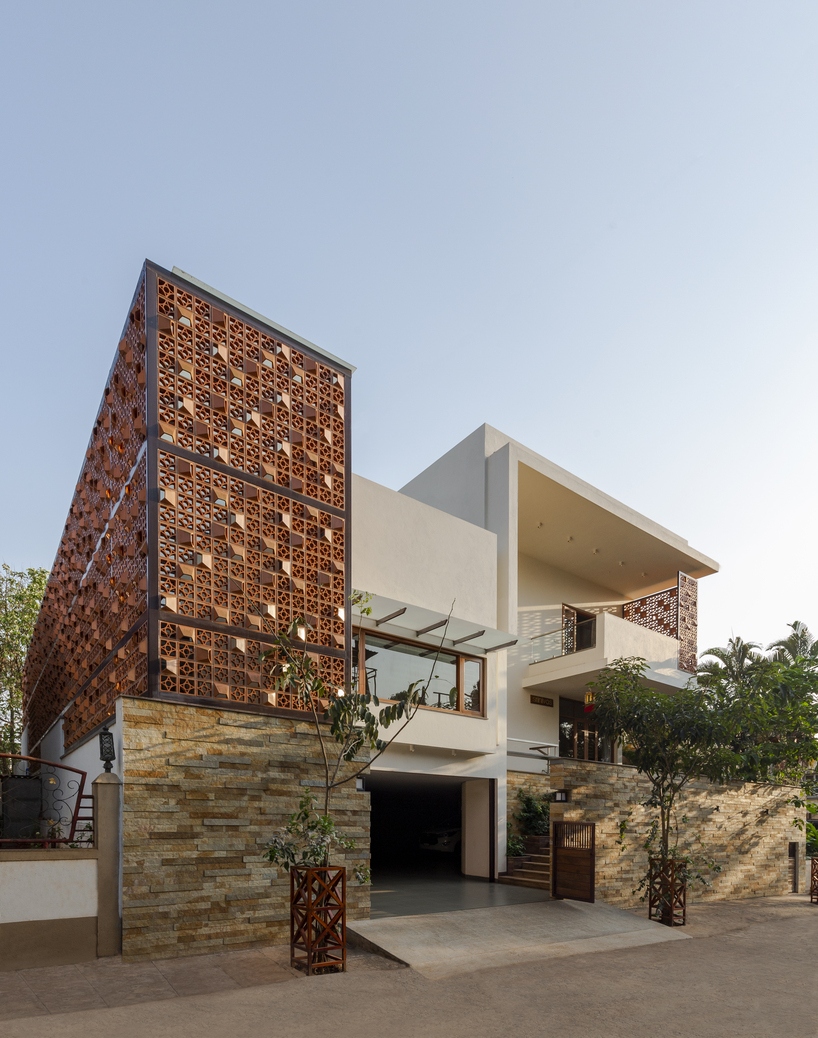 perforated terracotta screens enclose pool pavilion within indian residence