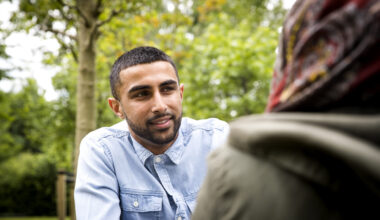 View over shoulder on man looking at friend