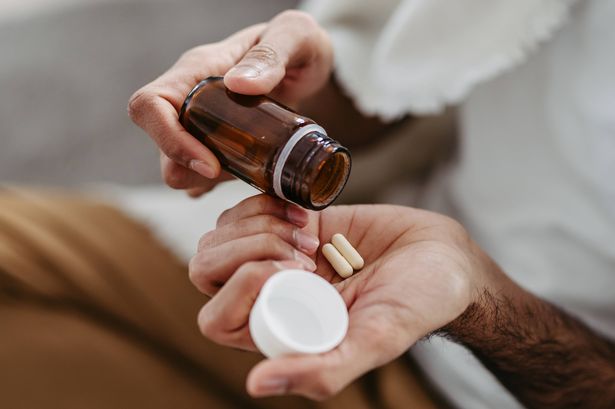 Close up of palm with pills from pill bottle. Man is sick, taking medication, painkillers, man with cold.