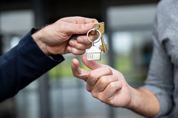 Close-up on a real estate agent giving a man the keys of his new house - home ownership concepts