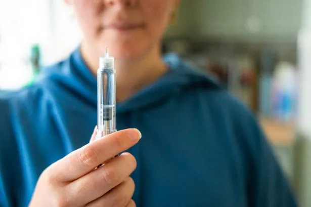 Close up of a woman's hands holding an injection pen