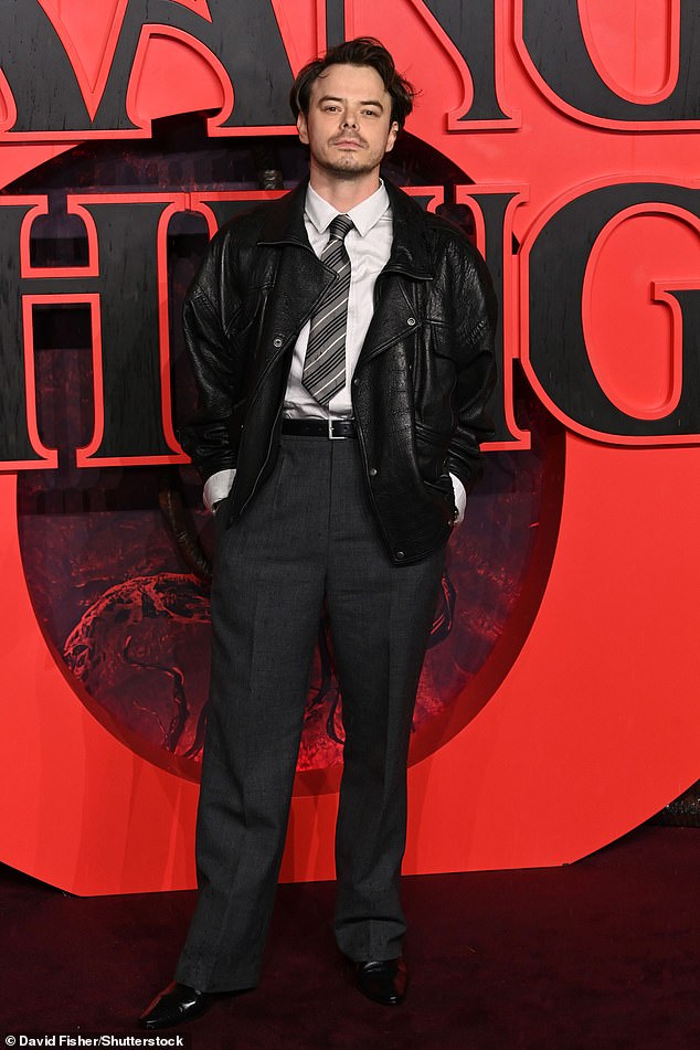 Charlie Heaton wore a shirt and tie with a leather biker jacket layered over