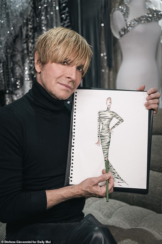 Bouwer is seen showing off one of his designs during a photoshoot with the Daily Mail