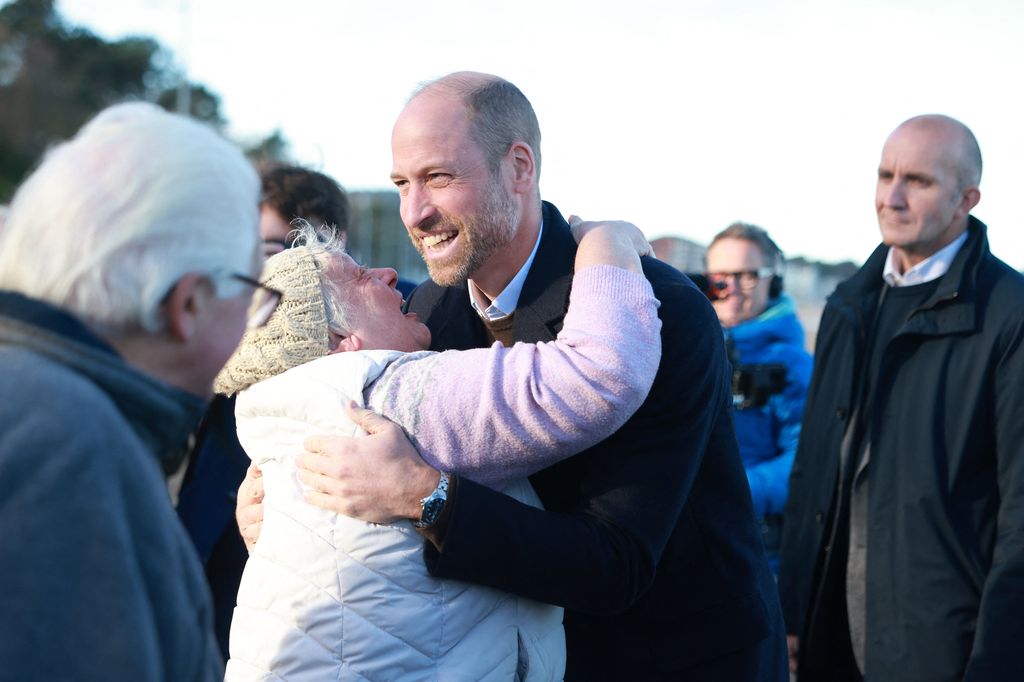 Prince William hugging member of public