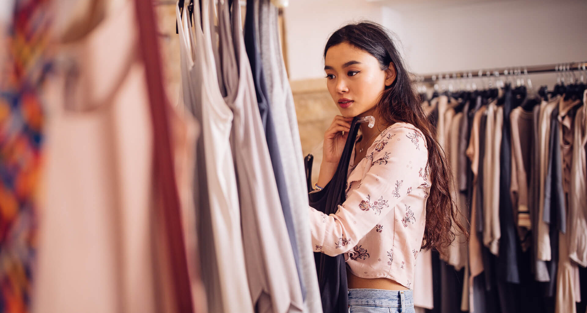 Beautiful young asian woman browsing and looking to buy summer clothes in a women
