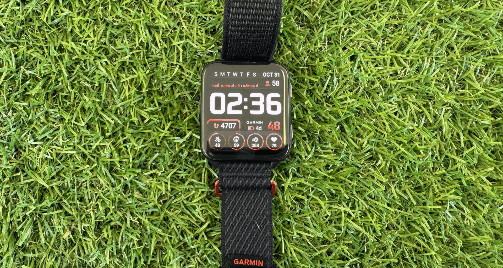 Garmin Venu X1 smart watch with black wrist band displayed on grassy background