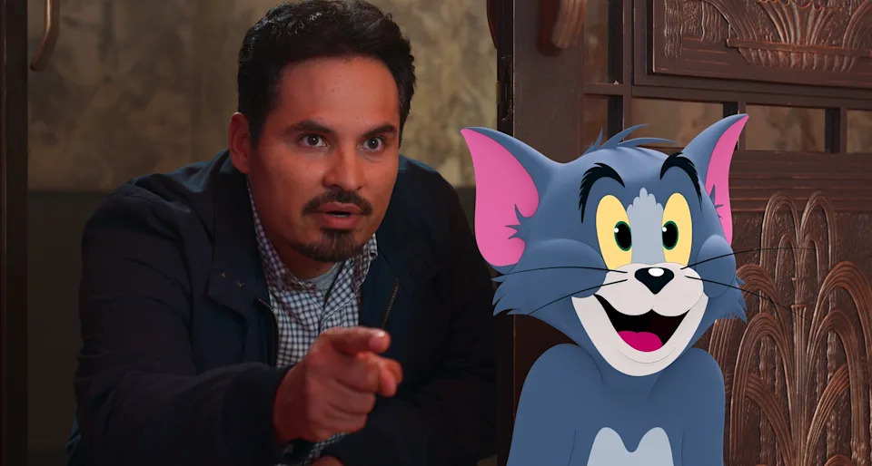 Michael Peña pointing while standing next to the animated character Tom from Tom and Jerry