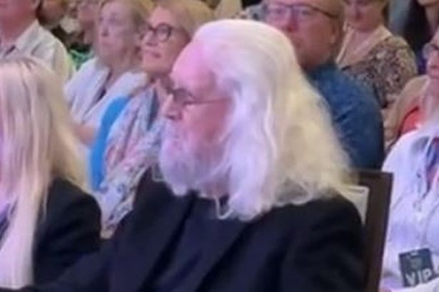 Billy Connolly sitting in a chair