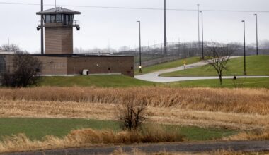 An observation tower and fence can be seen across from a field