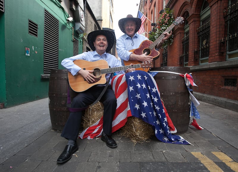 Then minister for tourism Paschal Donohoe and former minister of state Michael Ring embrace the red, white and blue of the US on Dame Lane in 2014. Photograph: Gareth Chaney/Collins