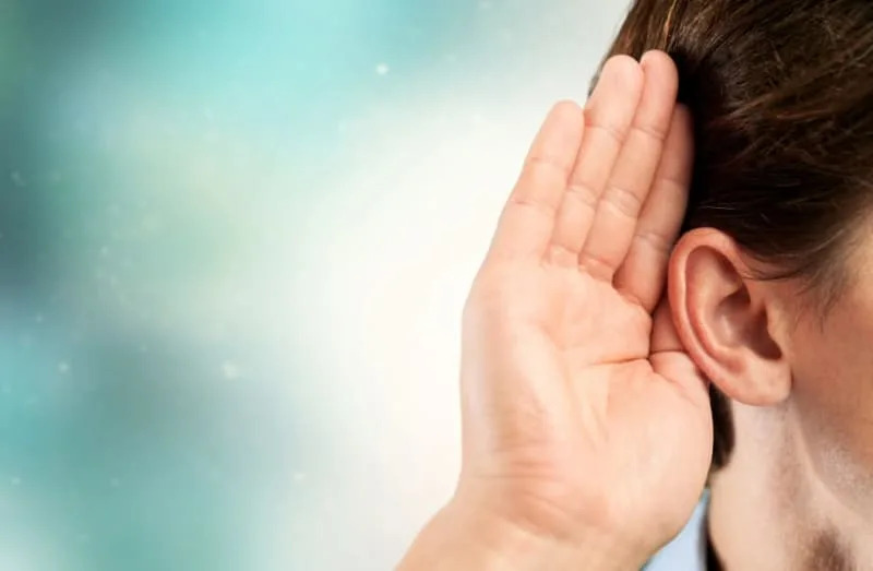 A person cups their hand to their ear in an act of listening (illustrative) (credit: SHUTTERSTOCK)