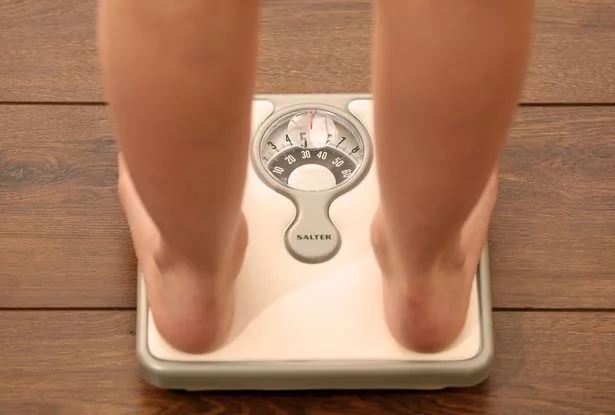 girl using a set of weighing scales. 
