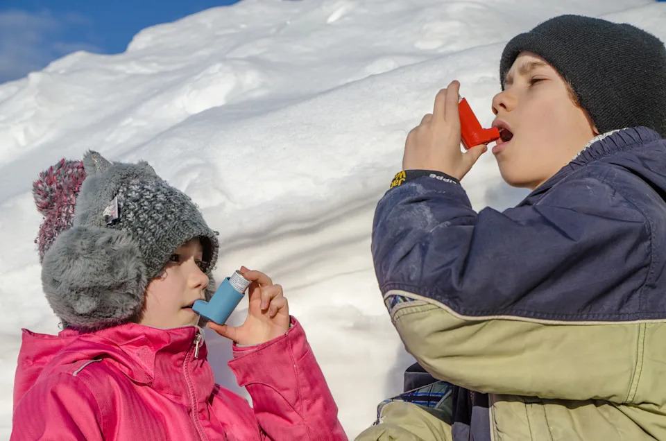Young boy and girl using asthma pump after snow shoveling after big snow fall