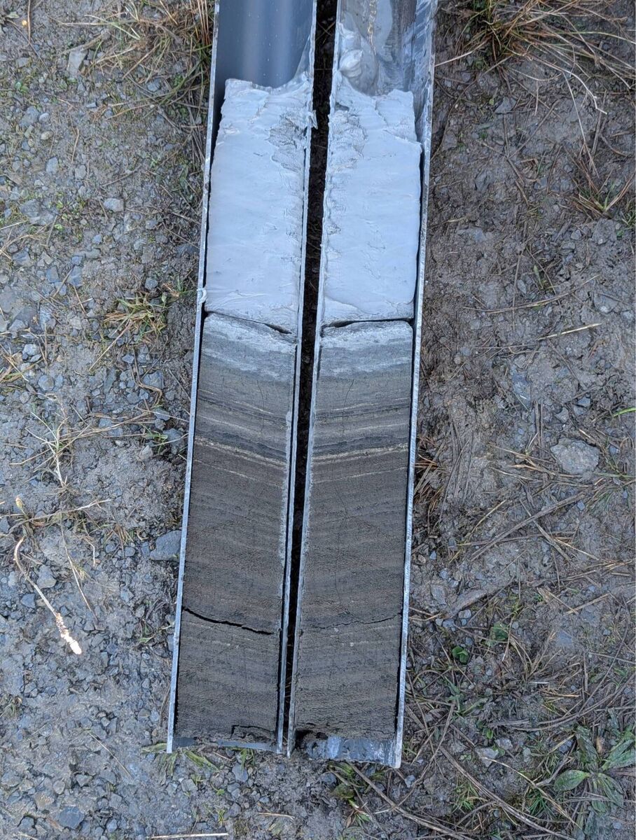 A split sediment core showing Late Glacial glaciolacustrine clay, deposited during deglaciation, sharply overlain by dark, organic-rich sediment. This colour transition marks the end of minerogenic input from retreating ice and the onset of organic lake sedimentation. Picture: Sarah Jane Power (University College Dublin)
