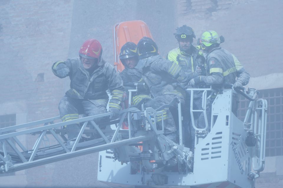 Firefighters work to rescue a construction worker at the partially collapsed medieval tower (Domenico Stinellis/AP)
