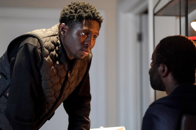 Okie looms over Kojo in a threatening manner in EastEnders