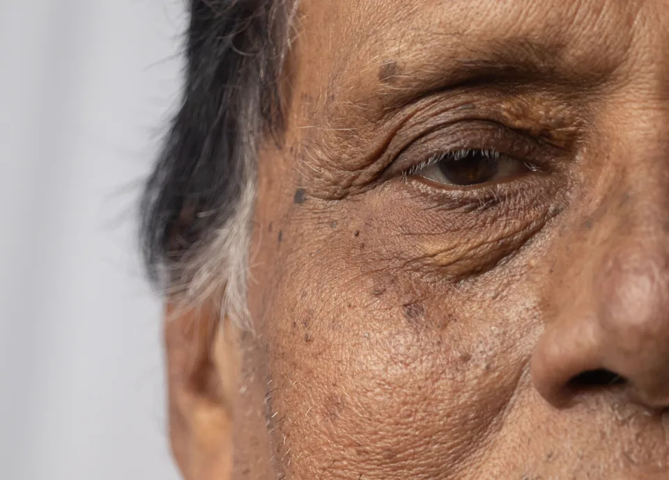 Close-up of an older person's face, showing wrinkles and texture, highlighting a life of experience and wisdom