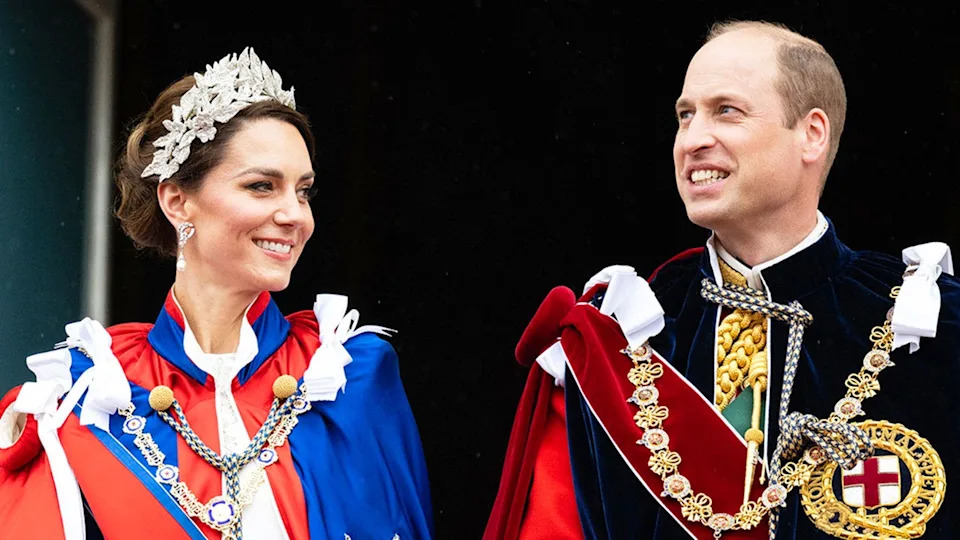 Prince William and Kate Middleton in royal robes smiling at each other.