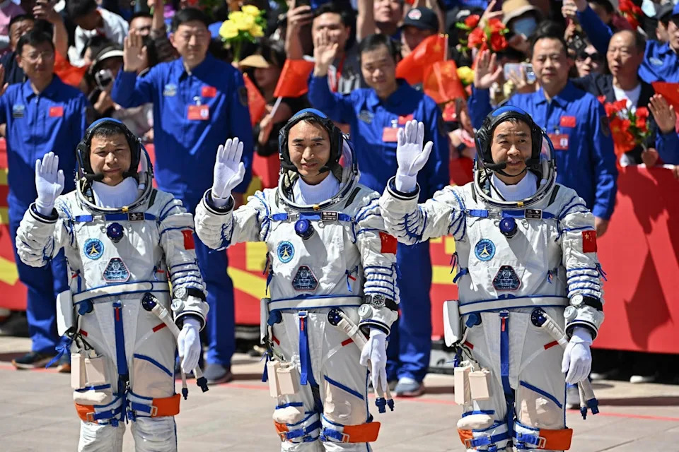 China's Shenzhou-20 space mission (L-R) Wang Jie, Chen Zhongrui, and Chen Dong, wave during a departure ceremony (AFP via Getty Images)