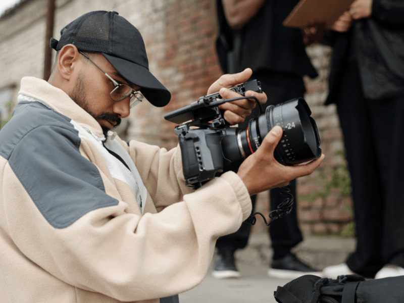 A professional film director recording footage with a video camera