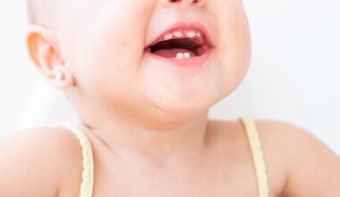 close up baby girl smiling with first teeth