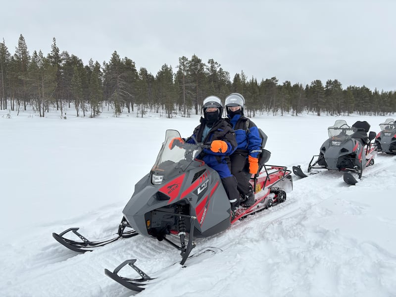 Natalie and August snowmobiling on Lake Menesjärvi, Inari, Finland