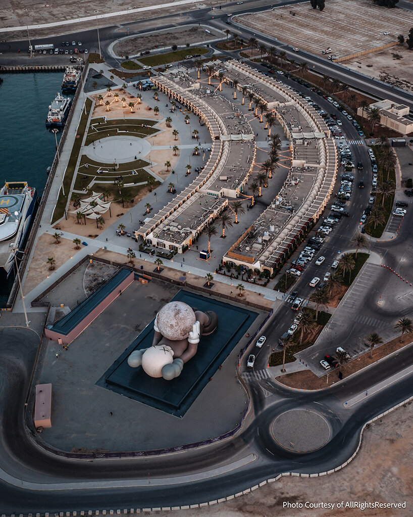 32-meter companion by KAWS lifts glowing moon along abu dhabi's waterfront