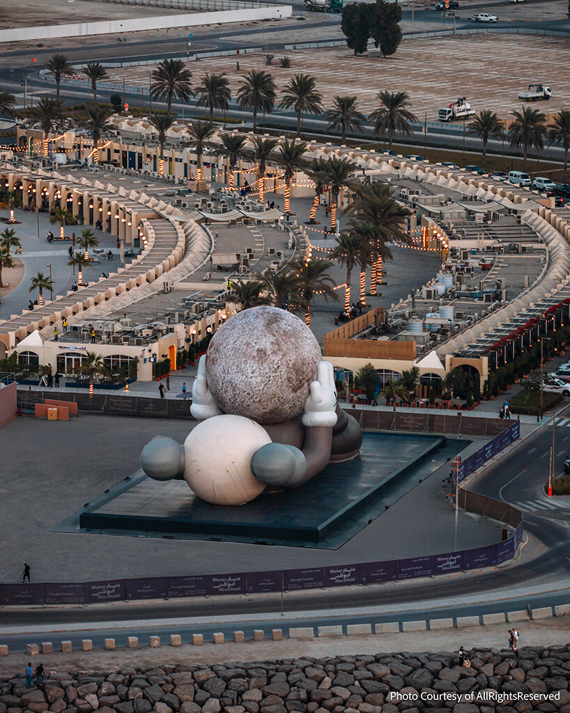 32-meter companion by KAWS lifts glowing moon along abu dhabi's waterfront