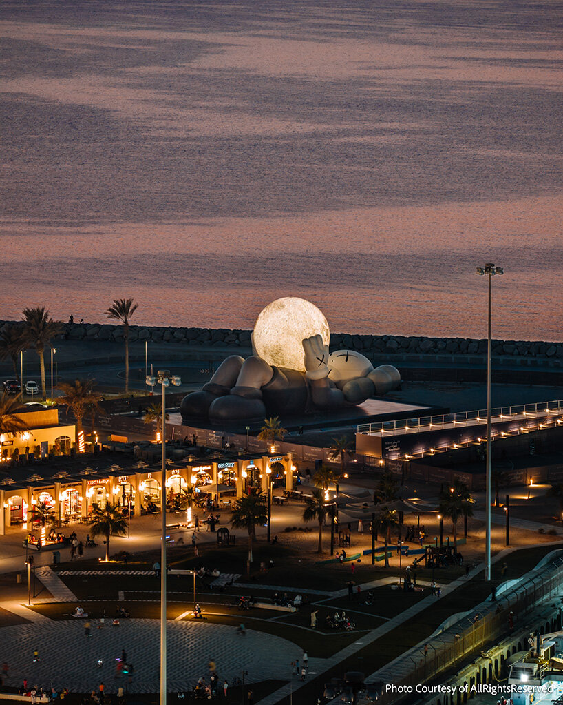 32-meter companion by KAWS lifts glowing moon along abu dhabi's waterfront