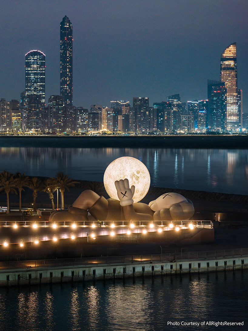32-meter companion by KAWS lifts glowing moon along abu dhabi's waterfront
